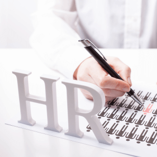 Female with pen white HR letters on desk